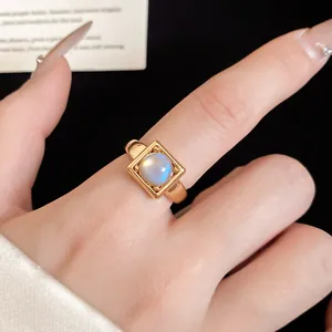 Close-up of 18k gold plated open ring with a square setting and round stone