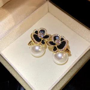 Detailed view of 14k real gold plated zircon flower stud earrings with elegant white pearls