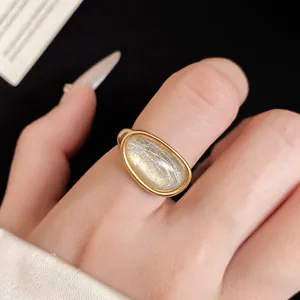 Close-up of minimalist 18k gold plated stone ring with adjustable band on finger