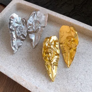 Vue macro de boucles d'oreilles en feuille de métal avec motif d'oreille
