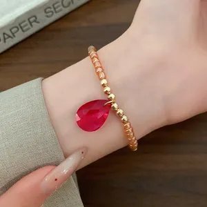 Bracciale di perle vintage con un vivace ciondolo in vetro rosso a forma di goccia sfaccettata
