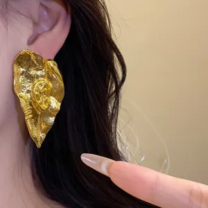 Boucles d'oreilles vintage en métal doré en forme de feuille avec texture plissée unique