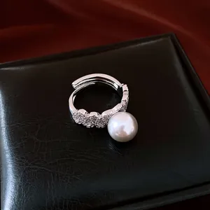 Elegant silver-toned adjustable ring featuring a large white pearl and pave stones