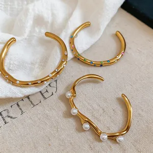 Detailansicht von goldenen Vintage-Edelstahlarmreifen mit Perlen und Kristallen.