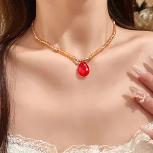 Vista dettagliata di una collana vintage di perline con un pendente a goccia in cristallo rosso