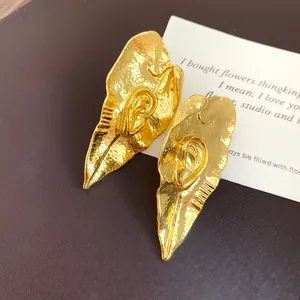 Gros plan détaillé des boucles d'oreilles vintage en métal au design de feuille