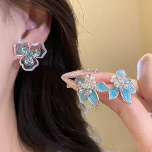 Elegante lichtblaue Öltropfen-Blumenohrringe mit Zirkon und Perlen auf Silbernadeln.