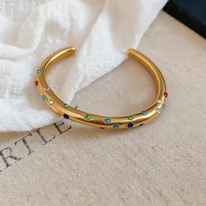 Detailansicht eines goldenen Armreifs aus Edelstahl im Vintage-Stil mit bunten Kristallen