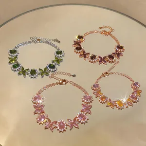 Eleganti bracciali floreali in zircone di vari colori su una superficie a specchio