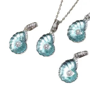 Elegant mint green seashell pendants with sparkling zircon accents on white background