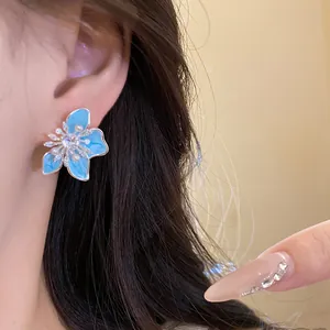 Detailansicht hellblauer Emaille-Blumenohrring mit Zirkonia- und Perlenakzenten