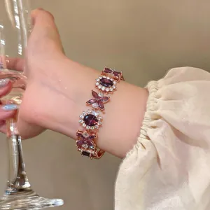 Dettaglio ravvicinato di un elegante bracciale in oro rosa con fiori di zircone viola.