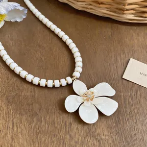 Detailed view of the elegant white flower pendant with bead chain for resort styling