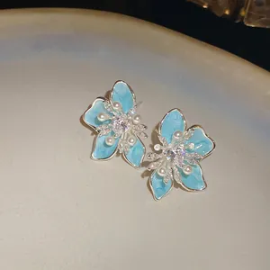 Detailansicht eleganter hellblauer Emaille-Blumenohrringe, verziert mit Perlen und Zirkonia