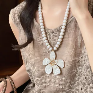 Detailed close-up showing the intricate texture of the white flower pendant jewelry