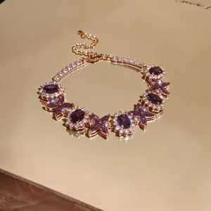 Dettaglio di un elegante bracciale in oro rosa con zirconi viola e tocchi di luce