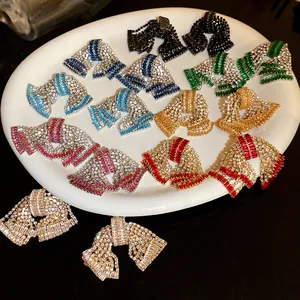 Macro detail view of colorful rhinestone bow earrings in various sparkling jewelry finishes.