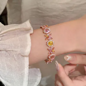 Primo piano di un elegante bracciale in oro rosa con zirconi a forma di fiori rosa
