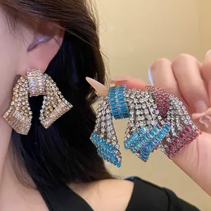 Macro detail of exaggerated bow earrings featuring dense sparkling zirconia rhinestones