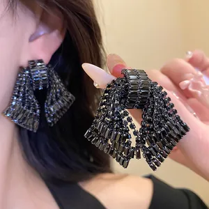 Close-up of exaggerated black rhinestone bow earrings with exquisite zircon inlay