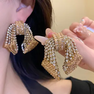 Detailed macro view of luxurious sparkling zircon bow dangle earrings for fashion jewelry.