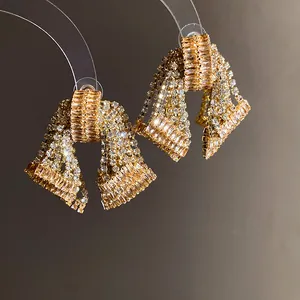 Macro view of luxurious gold-tone bow earrings with brilliant baguette zircons