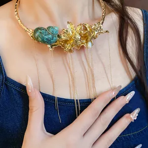 Detailed view of a vintage gold choker featuring a turquoise shell and floral design