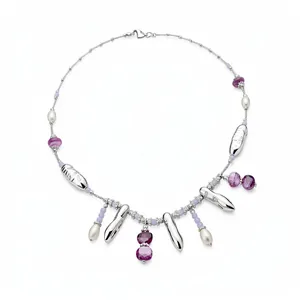 Collier minimaliste avec perles mauves et breloques en argent sur fond blanc pur.