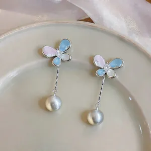 Detailed view of butterfly zircon earrings with long pearl tassels in Korean style.