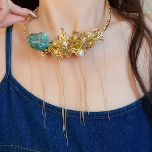 Close-up of vintage gold choker necklace featuring shell, pearl, and long tassels