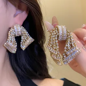 Close-up of sparkling zircon bow-knot earrings with silver needle posts for women.