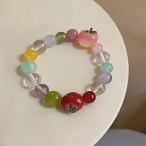 Detailed view of colorful beaded bracelet featuring charming resin apple pendants.