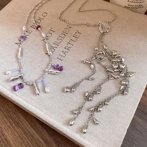 Vue détaillée d'élégants colliers à glands argentés avec perles violettes et nacres.