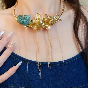Close-up of vintage gold flower and shell choker with long dangling tassels.