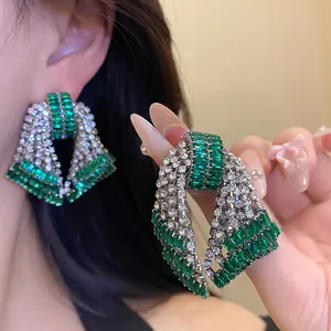 Detailed view of luxury green zircon bow earrings with shimmering diamond-like crystals.