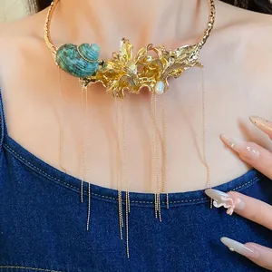 Detailed view of a vintage gold flower and seashell choker with long chain tassels