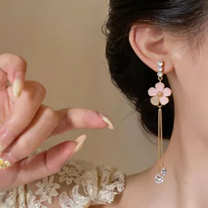 Close-up detail of pink enamel flower tassel earrings with zircon and crystal drops.