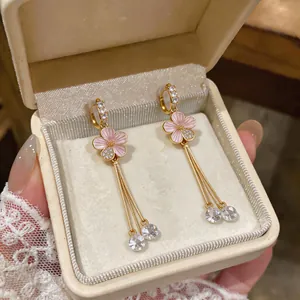 Elegant close-up of pink enamel flower tassel ear clips with cubic zirconia gems.