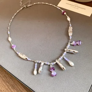 Collier ras-du-cou élégant avec pierres violettes, perles et pendentifs argentés.