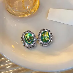 Vintage palace style oval resin earrings with green shimmer and rhinestones decoration