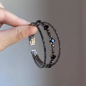Dettaglio ravvicinato di un bracciale elastico multistrato vintage con diamanti