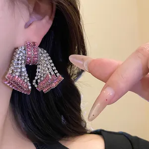Close-up detail of luxurious pink and clear zircon bow stud earrings on a model