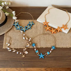 Detailed view of beach-themed necklaces with starfish, shells and pearls on burlap