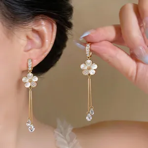 Macro detail view of elegant zircon flower tassel earrings with teardrop crystal pendants