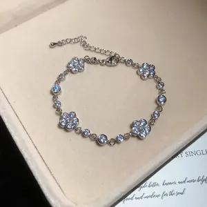 Detailansicht eines silbernen Blumenarmbands mit funkelnden Zirkonia-Steinen verziert.