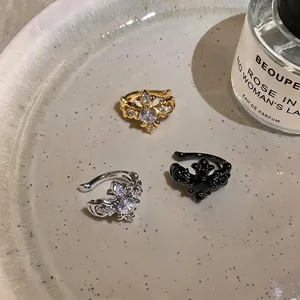 French light luxury zircon iris ear cuffs in gold silver and black shown on a plate