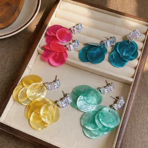 Close-up of colorful shell tassel earrings with sparkling zircons in a jewelry box