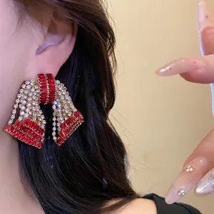 Exaggerated bow stud earrings with sparkling red zircon and clear rhinestones.