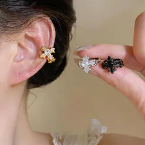 Detailed view of French luxury zircon fleur-de-lis cross ear cuffs in three colors