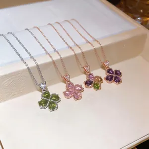 Macro view of four elegant flower zircon necklaces featuring varied gemstone colors